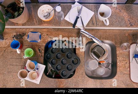 Tempo di fare alcuni piatti. Un lavello da cucina circondato da piatti. Foto Stock