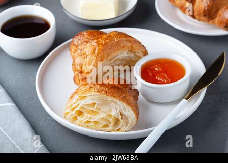 Croissant francese appena sfornato, burro e marmellata Foto Stock