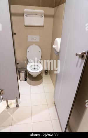 WC classico con porta aperta in un bagno pubblico Foto Stock