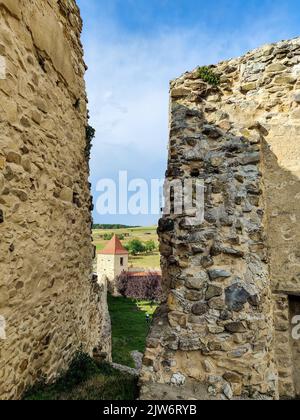 Vista della vecchia torre dalla piattaforma di osservazione dell'antica fortezza di Rupea in Romania contro il cielo blu con le nuvole. La fortezza fu costruita sulle rovine dell'ex Dacia Foto Stock