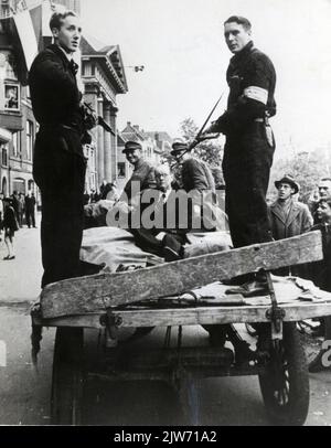 Immagine di un N.S.B.-er arrestato e di due soldati tedeschi su un carro, sorvegliati da due membri armati delle forze interne (B.S.), sul cinema Oudegracht di Utrecht presso il Teatro Rembrandt (Oudegracht 73). Foto Stock