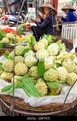 Mercato di strada vietnamita e commerciante che indossa cappello di bambù, Hai Phong, Vietnam Foto Stock