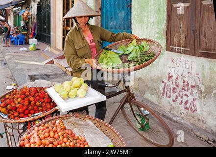 Mercato di strada vietnamita e commerciante che indossa cappello di bambù, Hai Phong, Vietnam Foto Stock