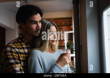 Giovane coppia che guarda attraverso la finestra Foto Stock
