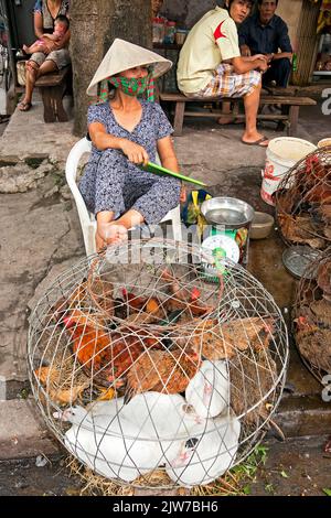 Mercato di strada vietnamita e commerciante che indossa cappello di bambù, Hai Phong, Vietnam Foto Stock