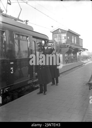 Immagine di un conduttore del N.S. Che dà il segnale di partenza sulla piattaforma della stazione N.S. Utrecht et al. Di Utrecht, con un treno elettrico impostato. 1924 ('scatole a blocchi'). Sullo sfondo il Seinhuis Post A. Foto Stock