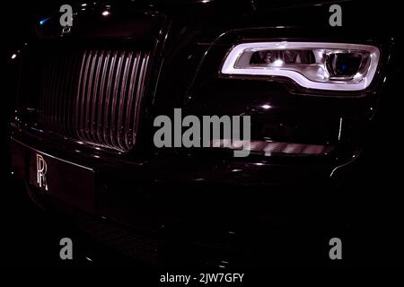 Dettagli ravvicinati della griglia anteriore per auto di lusso Rolls-Royce e dei fari a LED con un'illuminazione spettacolare Foto Stock