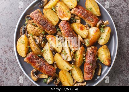 Conforto cibo involtini di carne con funghi e patate primo piano in un piatto sul tavolo. Vista orizzontale dall'alto Foto Stock