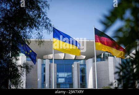 Berlino, Germania. 04th Set, 2022. La bandiera dell'Ucraina vola tra la bandiera europea (l) e la bandiera tedesca (r) di fronte alla Cancelleria federale. L'occasione è la visita del primo ministro ucraino nella capitale. Credit: Kay Nietfeld/dpa/Alamy Live News Foto Stock