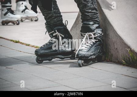 Un primo piano di skate aggressivi in linea presso lo skatepark Foto Stock