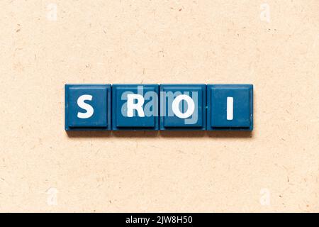 Tile letter in inglese SROI (abbreviazione di Social Return on Investment) su sfondo legno Foto Stock