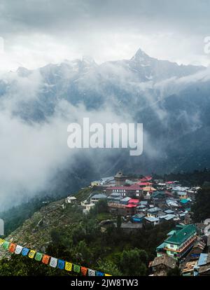 Vista elevata del villaggio di Kalpa e Himalaya con creste affilate come sfondo in una mattina misty in estate a Kalpa, Himachal Pradesh, India. Foto Stock
