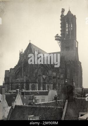 Vista del coro del Domkerk (Munsterkerkhof) a Utrecht, da nord-est, con la torre del Duomo dietro di essa durante il restauro della lanterna; in primo piano il tetto della casa dietro St.-Pieter 15 e i tetti di alcune case nel Voetiussteeg.n.b. Nel 1907 la casa alle spalle di St.-Pieter 15 fu demolita per l'ampliamento del Voetiussteeg. Il nome della strada Voetiussteeg è stato cambiato in Voetiusstraat nel 190 e il nome della strada Munsterkerkhof è stato cambiato in Domplein nel 1912. Foto Stock