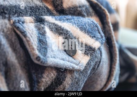 Pulsante su una camicia calda blu, scatto macro. Foto Stock