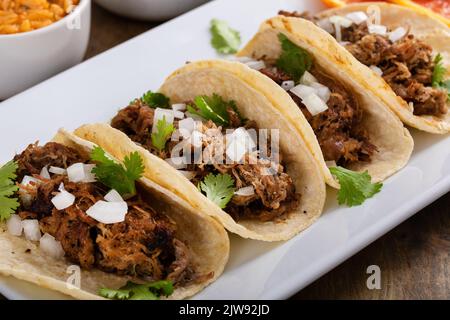 Carnitas tacos di maiale su tortillas di mais con riso e fagioli Foto Stock