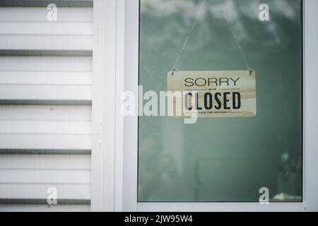 Siamo spiacenti, il cartello è chiuso. Immagine grunge appesa a una porta di vetro. Foto Stock
