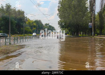 Alluvione. Strada e automobili sotto l'acqua. Piogge intense e precipitazioni inondate di acqua per le strade della città. Forte diluvio. Anomalia naturale. Maltempo. Cataclisma. Auto Foto Stock