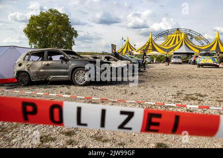 Duisburg, Germania. 04th Set, 2022. I veicoli bruciati si trovano di fronte alla tenda del circo FlicFlac dopo che un piccolo aereo si è schiantato lì. Due persone sono state uccise quando il piccolo aereo si è schiantato vicino all'autostrada A59 vicino a Duisburg. Credit: Christoph Reichwein/dpa/Alamy Live News Foto Stock