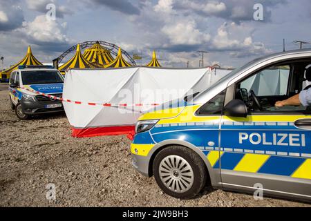 Duisburg, Germania. 04th Set, 2022. I veicoli di emergenza della polizia si trovano in un parcheggio non lontano dalla tenda del circo FlicFlac dopo che un piccolo aereo si è schiantato lì. Due persone sono state uccise quando il piccolo aereo si è schiantato vicino all'autostrada A59 vicino a Duisburg. Credit: Christoph Reichwein/dpa/Alamy Live News Foto Stock