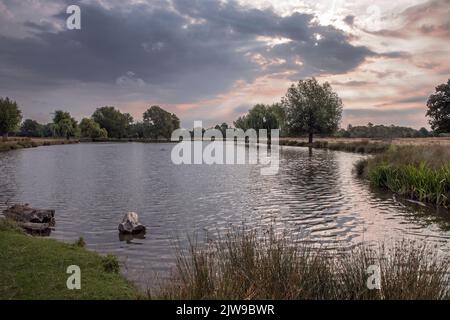 Nuvole di tempesta che si radunano sugli stagni di Bushy Park nel Surrey Inghilterra Foto Stock