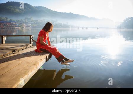 asian lady ritratto rilassarsi in stile cinese a lungo vestito o vietnam accessori contemporanei felice sul luogo mattina Foto Stock