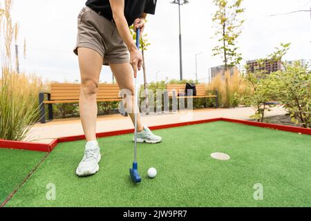 Primo piano del giocatore giocare a mini golf con palla Foto Stock