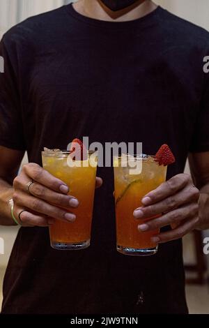 Barista che mostra al cliente la bevanda che ha appena preparato. Atmosfera da night club o da festa. Bevande di classe. Vita notturna Foto Stock