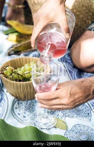 Donna che tiene un bicchiere mentre viene servito vino. Atmosfera rilassata. All'aperto Foto Stock