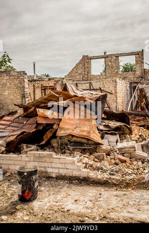 Casa in rovina. Rovine di un edificio residenziale. Muri di mattoni. Guerra in Ucraina. Una casa distrutta da un razzo e da un fuoco. Un mucchio di mattoni. Una vita bruciata. Foto Stock