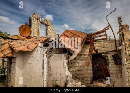 Rovine di una casa privata. Casa bruciata. Un'arrugginita parabola satellitare. Vita rovinata. Resti dell'edificio. Guerra in Ucraina. Casa bruciata. Missile colpito. Foto Stock