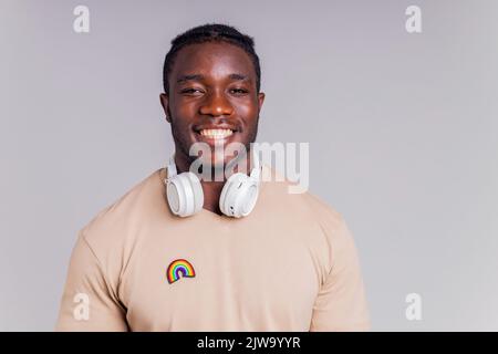 uomo messicano con cuffie bianche che ascolta musica in t-shirt beige Foto Stock