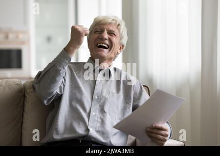 Felice eccitato anziano pensionato uomo godendo trionfo, vincere Foto Stock