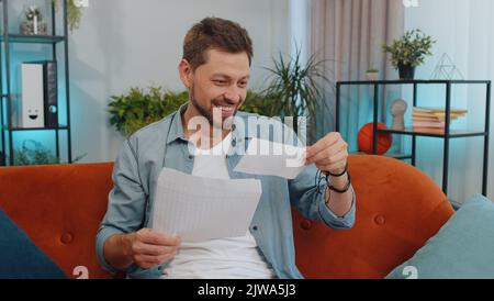 Felice ragazzo aperto busta lettera, la lettura. Promozione avanzamento di crescita della carriera, approvazione prestito bancario, ammissione di successo al premio monetario universitario a lungo atteso invito grande notizia, vincita gioco lotteria Foto Stock