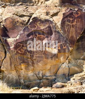 Arte rupestre dei petroglifi in Legend Rock state Archaeological Site, Wyoming - pannelli in arenaria intagliata con figure animali antropomorfe e zoomorfe Foto Stock