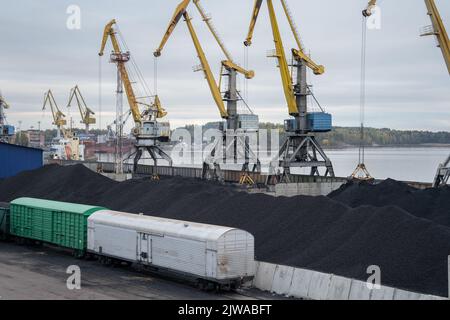 Carico di antracite di carbone nei carri merci ferroviari in porto con benna gru Foto Stock