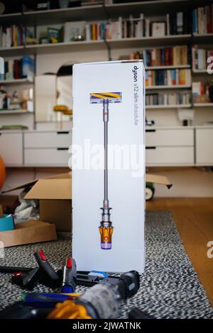 Parigi, Francia - Lug 16, 2022: Confezione sconfezionato del nuovo aspirapolvere cordless a batteria da Dyson V12 slim Absolute con ripiani in Vitsoe sullo sfondo Foto Stock