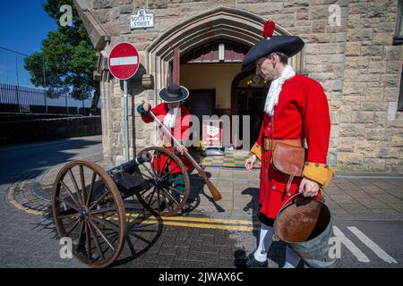 Apprendisti ragazzi con cannone che reagiscono l'assedio storico di Derry nelle mura della città, Londonderry, Derry, Irlanda del Nord. Foto Stock