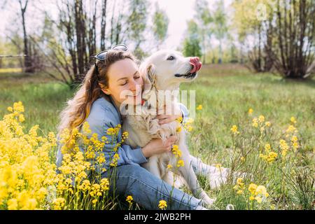 Giovane bella donna e il suo cane Golden Retriever divertirsi in estate Foto Stock