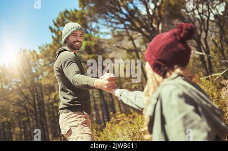 Sia male quella mano per aiutarla in su. Un uomo che dà alla sua ragazza una mano mentre fuori che fa trekking. Foto Stock