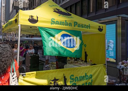 NEW YORK, NEW YORK - 04 SETTEMBRE: Le persone che indossano camicie e bandiere brasiliane godono di una fiera di strada sulla Sixth Avenue in luogo della festa brasiliana a New York il 4 settembre 2022. Per il terzo anno consecutivo, il BR Day New York, il più grande partito brasiliano al di fuori del Brasile, non si svolge. João de Matos, presidente del BR Day NY, dice che l'evento che ha partecipato comunemente da 1. Credit: Ron Adar/Alamy Live News Foto Stock