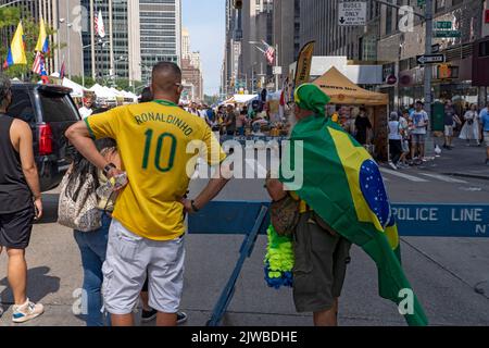 NEW YORK, NEW YORK - 04 SETTEMBRE: Le persone che indossano camicie e bandiere brasiliane godono di una fiera di strada sulla Sixth Avenue in luogo della festa brasiliana a New York il 4 settembre 2022. Per il terzo anno consecutivo, il BR Day New York, il più grande partito brasiliano al di fuori del Brasile, non si svolge. João de Matos, presidente del BR Day NY, dice che l'evento che ha partecipato comunemente da 1. Credit: Ron Adar/Alamy Live News Foto Stock