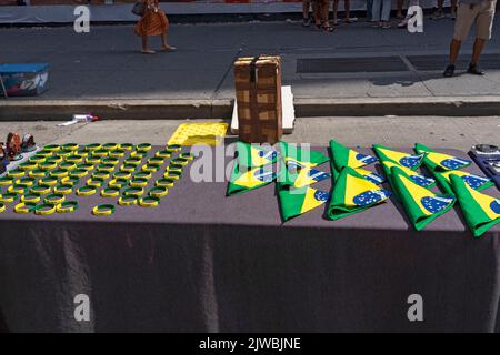 Bandana e braccialetti brasiliani in mostra in una fiera di strada sulla Sesta Avenue in sostituzione della festa brasiliana a New York. Per il terzo anno consecutivo, il BR Day New York, il più grande partito brasiliano al di fuori del Brasile, non si svolge. João de Matos, presidente del BR Day NY, afferma che l'evento a cui hanno partecipato 1,5 milioni di persone è stato sospeso a causa di una combinazione di fattori, tra cui il recente scoppio di monkeypox a New York; recenti manifestazioni a causa delle elezioni presidenziali in Brasile il prossimo ottobre; e questioni logistiche e di trasporto aereo. Foto Stock