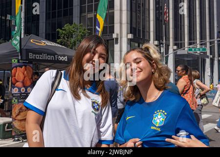 Le persone che indossano camicie e bandiere brasiliane godono di una fiera di strada sulla Sesta Avenue in sostituzione della festa brasiliana a New York. Per il terzo anno consecutivo, il BR Day New York, il più grande partito brasiliano al di fuori del Brasile, non si svolge. João de Matos, presidente del BR Day NY, afferma che l'evento a cui hanno partecipato 1,5 milioni di persone è stato sospeso a causa di una combinazione di fattori, tra cui il recente scoppio di monkeypox a New York; recenti manifestazioni a causa delle elezioni presidenziali in Brasile il prossimo ottobre; e questioni logistiche e di trasporto aereo. Foto Stock