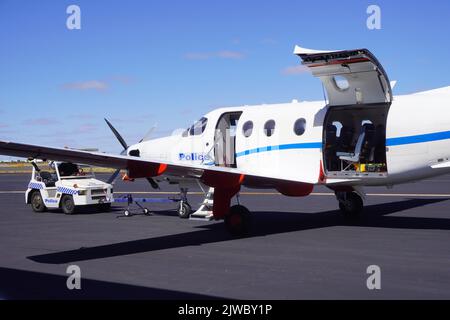 Velivolo di polizia e Tug sul grembiule all'Aeroporto di Alice Springs Foto Stock