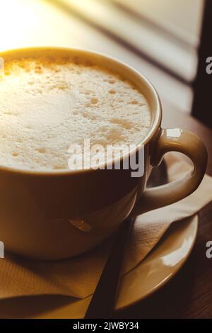 Tazza di cappuccino latte. Mattina caffè estetica vibrazioni. Prima colazione. Ombre dure. Luce delicata. Cappuccino al mattino per la prima colazione al bar. Sfondo. Accogliente caffetteria Foto Stock