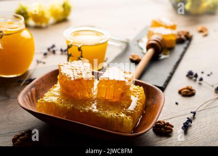 Nido d'ape su vassoio di ardesia con miele e noci sul tavolo da cucina Foto Stock
