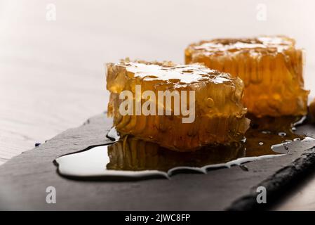 Nido d'ape su vassoio ardesia sul tavolo da cucina vista macro Foto Stock