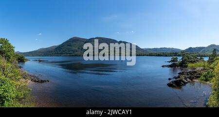 Muckross, Irlanda - 10 agosto, 2022: I turisti si godono un giro in barca sul lago Muckross nel Parco Nazionale di Killarney in una bella giornata estiva Foto Stock