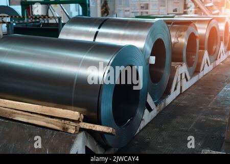 Rotoli di lamiere di acciaio. Bobine metalliche in officina di fabbrica di metalli. Foto Stock