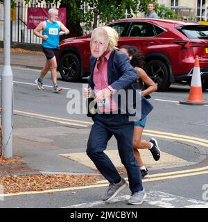 Un corridore vestito come Boris Johnson che corre in una mezza maratona Foto Stock